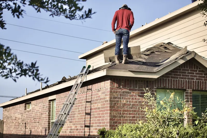 Professional roofer working on a residential roof in Sand Springs